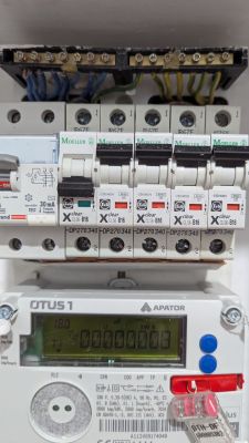 Rozdzielnica elektryczna z licznikiem Apator i wyłącznikami B16 Widok rozdzielnicy elektrycznej z zamontowanym licznikiem Apator OTUS 1 oraz wyłącznikami nadprądowymi typu B16 i wyłącznikiem różnicowoprądowym.