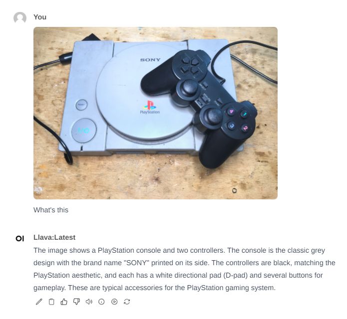 PlayStation Console with Controller PlayStation console with one black controller on a wooden table.