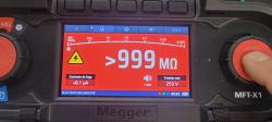 Ekran miernika Megger pokazujący oporność izolacji ponad 999 MΩ przy napięciu 253 V