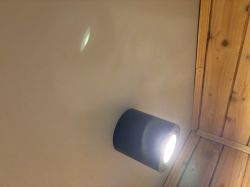 Lampa sufitowa z LED emitująca światło na jasnym tle.
