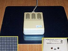 Computer mouse with three buttons on a black pad with a cable.