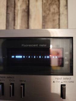 Fluorescencyjny miernik na urządzeniu audio z wyświetlanymi wartościami dB.