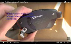 Zbliżenie na klocki hamulcowe Brembo z metalowym klipsem ostrzegającym o zużyciu.