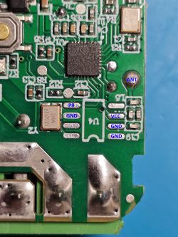 Close-up of a green circuit board with various electronic components and labels.