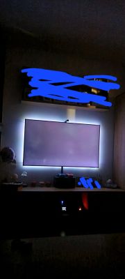 Telewizor QLED z białymi plamami na ekranie w ciemnym pokoju