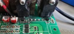 Zbliżenie na uszkodzoną płytkę PCB spawarki inwertorowej z widocznymi elementami elektronicznymi i spaloną sekcją.