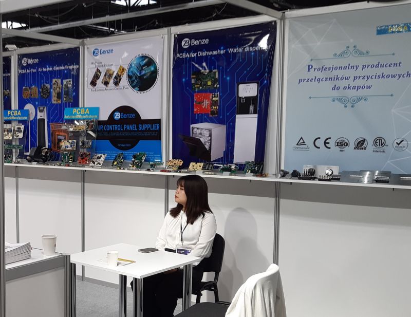 Stoisko targowe z elektroniką PCBA, kobieta siedząca przy stole.