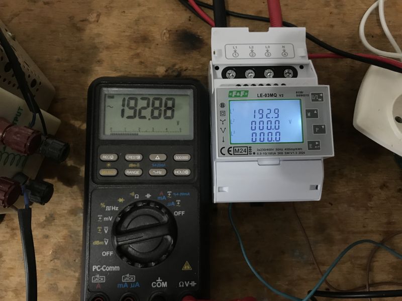Multimetr i trójfazowy licznik energii elektrycznej LE-03MQ na stole.