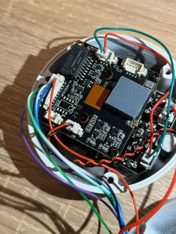 Widok wnętrza kamery IP z widoczną płytką PCB i kolorowymi przewodami