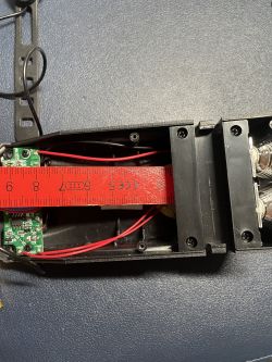 Wnętrze urządzenia elektronicznego z miarką, pokazującą wymiary 4 cm na 7,5 cm.