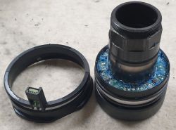 Elektroniczny komponent rowerowy z dużymi pierścieniami i widocznym okablowaniem.