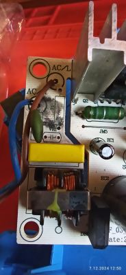 Zniszczona płytka elektroniczna z widocznymi komponentami.