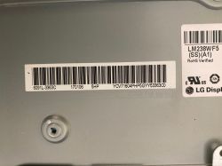 Zbliżenie na tylną stronę uszkodzonej matrycy LG Display LM238WF5 SS A1 z etykietą.