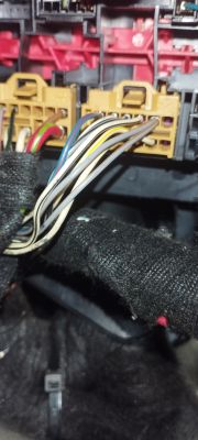 Zbliżenie na złącza elektryczne z przewodami o różnych kolorach w samochodzie.