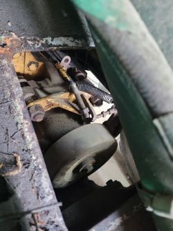 Pasek napędowy i elementy mechanizmu gazu w ładowarce, widoczne sprężyny i linka.