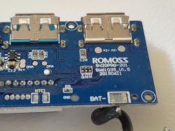 Fragment płytki drukowanej powerbanku ROMOSS z dwoma gniazdami USB typu A oraz widocznymi oznaczeniami modelu i wersji.