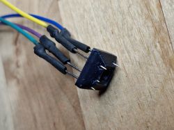 3D printed socket with four wired pins resting on a wooden surface