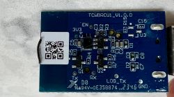 PCB with QR Code Sticker Blue PCB with electronic components and a white QR code sticker.