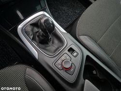 Manual gear stick and control panel in a car's center console.