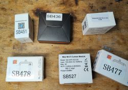 Several boxes of smart home modules on a wooden table.