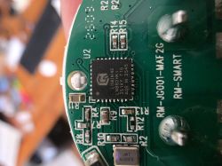 Close-up of a green PCB with an IC and SMD parts; “RM‑SMART” text visible.