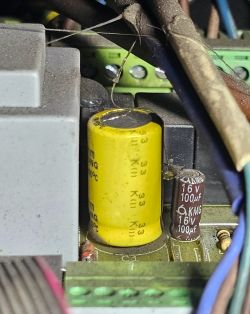 Zbliżenie płytki sterownika z żółtym kondensatorem elektrolitycznym i brązowym 16V 100µF