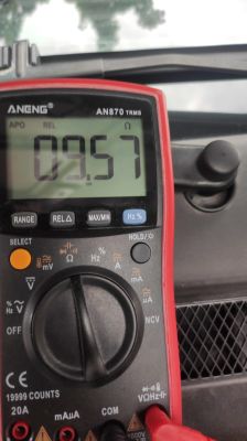 Wyświetlacz multimetru pokazuje oporność 9,57 Ohm, miernik ANENG AN870 TRMS w trybie pomiaru rezystancji.