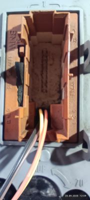 Zbliżenie na brązową kostkę elektryczną z trzema przewodami wewnątrz
