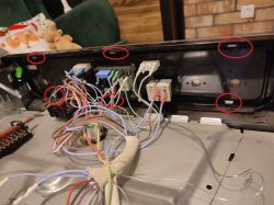 Widok wnętrza urządzenia elektrycznego z widocznymi przewodami i złączami.