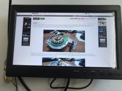 Small desktop monitor displays the elektroda.pl website via HDMI; control buttons are visible on the bezel.