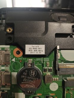 Zdjęcie wnętrza laptopa Dell Inspiron 15 3000 z widocznym oznaczeniem płyty głównej i baterią litową CR2032.