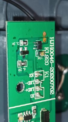 Zbliżenie na uszkodzoną zieloną płytkę PCB z elementami SMD i oznaczeniami HJH0046.
