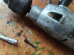 Old Celma PRCb Drill on Table Old Celma PRCb drill on a wooden table, with a socket wrench and a screw nearby.