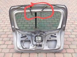 Zdjęcie tylnej klapy samochodu z zaznaczonymi przelotkami kabli.
