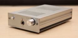 Metal casing of a headphone amplifier with volume knob and headphone jack on the front panel.
