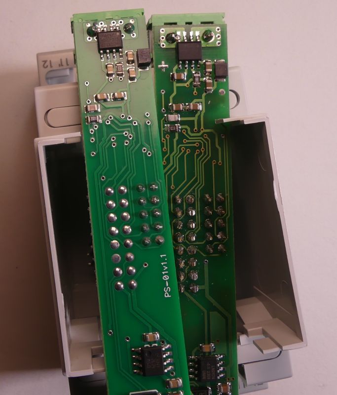 Dwie zielone płytki drukowane z widocznymi ścieżkami, elementami elektronicznymi oraz białą obudową w tle.