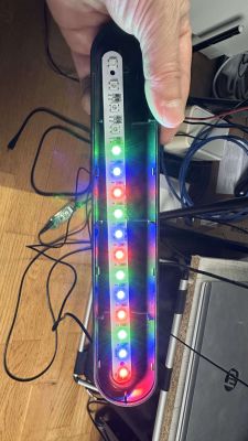 LEDs shining in various colors on a simple electronic set held by a hand.