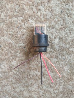 Złącze RJ45 z przewodami o kolorach czerwonym, brązowym, pomarańczowym i czarnym.