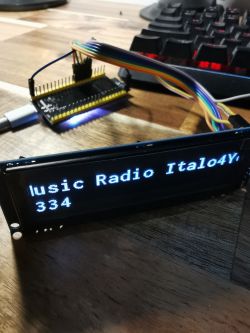 LCD display connected to a microcontroller with the message music Radio Italo4Y 334 displayed.