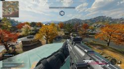 Gracz z widokiem z pierwszej osoby celuje bronią na kolorową, jesienną mapę w grze FPS.
