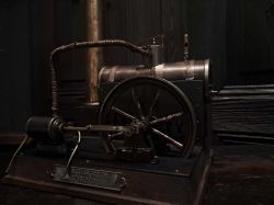 Zdjęcie naprawionego modelu maszyny parowej Lipsi na ciemnym tle.