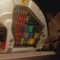 Skrzynka bezpieczników z kolorowymi bezpiecznikami o różnych wartościach.