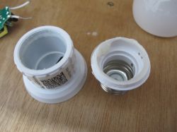 Partially disassembled LED bulb on a wooden surface.
