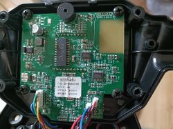 Zbliżenie na płytkę elektroniczną z widocznymi podzespołami i kolorowymi przewodami.