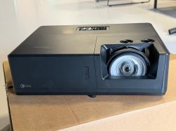 Projektor Optoma ZU507TST o krótkim rzucie ustawiony na kartonie