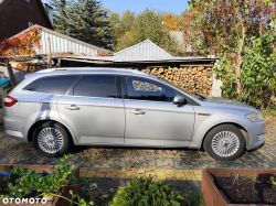Silver Ford Mondeo station wagon parked on a driveway with a woodshed in the background.