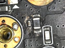 PCB close-up with SMD capacitors and signs of corrosion or damage