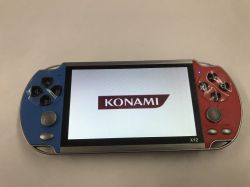 X12 handheld game console with blue and red grips, screen showing KONAMI logo