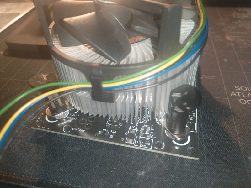 Heatsink with a fan mounted on a circuit board with colorful cables.