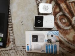 Wireless video doorbell set: camera unit, speaker receiver, and Setty box on a patterned carpet